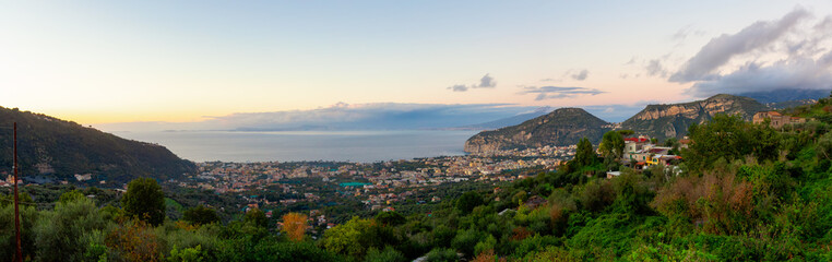 Fototapeta premium View of Touristic Town, Sorrento, Italy. Coast of Tyrrhenian Sea. Cloudy Sky Sunset. Panorama