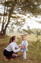 Fototapeta premium beautiful and happy mother and daughter have a good time in the forest