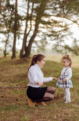 Fototapeta premium beautiful and happy mother and daughter have a good time in the forest