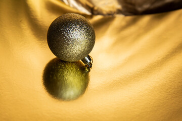 golden christmas ball on gold color background 