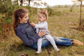 Fototapeta na wymiar beautiful and happy mother and daughter have a good time in the forest