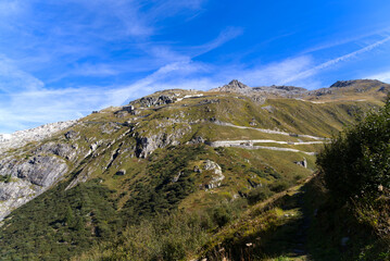 Aerial view of mountain panorama in the Swiss Alps at region of Swiss mountain pass Furkapass with serpentine road on a sunny summer day. Photo taken September 12th, 2022, Furka Pass, Switzerland.