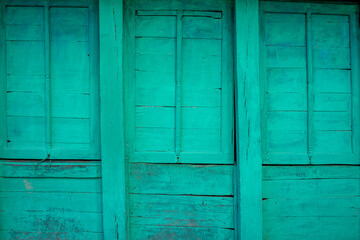 Mint weathered wooden facade. The old, traditional house is painted in a mint green colour. solid grunge background