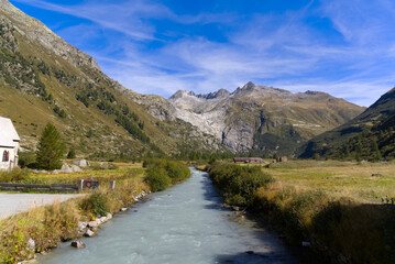 Scenic view of glacier landscape with Rhone River and serpentine road at Swiss mountain pass Furkapass on a sunny late summer noon. Photo taken September 12th, 2022, Furka Pass, Switzerland.