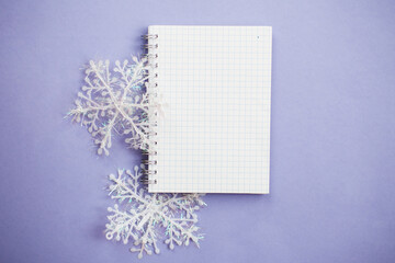 empty notebook for writing wish list with snowflake on a purple background