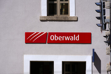 Red sign at railway station and terminal of car shuttle train at mountain village Oberwald, Canton Valais, on a sunny late summer day. Photo taken September 12th, 2022, Oberwald, Switzerland.