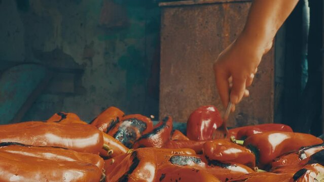 Roasting red peppers for a smoky flavor and quick peeling. Thermal processing of the pepper crop on metal circle. Brazier container used to burn charcoal fuel for cooking or heating. Bulgarian pepper