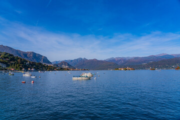 Small wood boats at the lake Maggiore at Stresa, landscapes over the lake in the backgound the alps