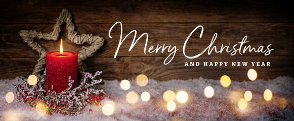 Christmas Greeting Card with English text Merry Christmas and Happy New Year. Panorama, Banner. Christmas candle in winter snow landscape with magic lights. Xmas Wood background with copy space.
