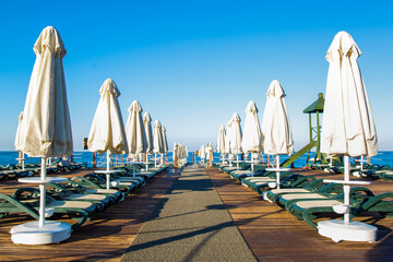 Wooden Panton with Sun Umbrellas and Sunbeds in a Turkish Hotel.
