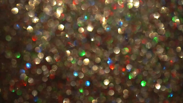 Multicolor bokeh lights abstract motion. Glitter Bokeh 4K video. Slow Motion Shot of falling golden and colourful particles bokeh.