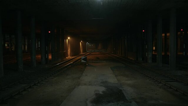 Abandoned railway / subway platform. Ghetto. Rainy autumn foggy weather in the night city. Gotham city mood. Cinematic style. Dungeon columns and dim light. Graffiti on the walls. 