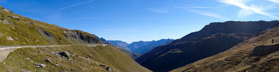 Beautiful wide angle mountain panorama at summit of Swiss mountain pass Furkapass with Ursern Valley on a sunny late summer day. Photo taken September 12th, 2022, Furka Pass, Switzerland.