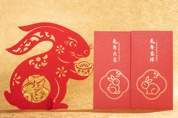 Chinese New Year of Rabbit mascot paper cut with red pockets on gold background at vertical...