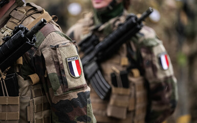 France Army soldiers uniform. Close up photo with the France flag on a military soldier uniform with the gun next to it. Military industry concept photo. - obrazy, fototapety, plakaty