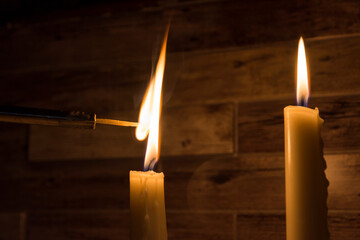 A burning match, a match lights up from a candle, a candle and a match