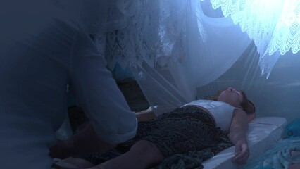 male masseur massages the legs in a beautiful white ornamrental tent.