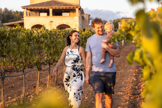 Happy family taking a walk through a Mediterranean vineyard
