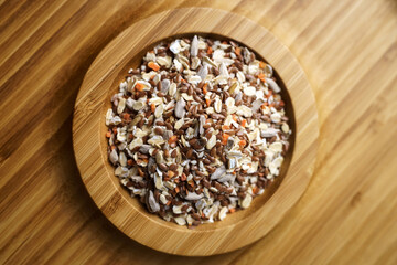 Mixture of spices for baking on a wooden plate. Includes flax sesame and sunflower seeds