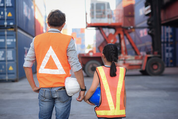 back side Asian father who owns an import-export industry and warehouse business. Holding hard hat and introducing and educate her knowledge  of work for a daughter who wants to learning