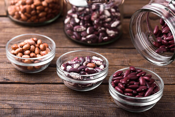 Red beans in a transparent glass over wooden background.