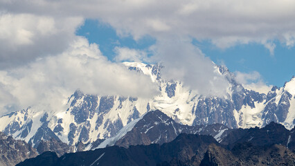 Naklejka premium permafrost. glaciers. snowy mountain peaks and cliffs. snowy mountains in hot summer. mountain peaks in the clouds