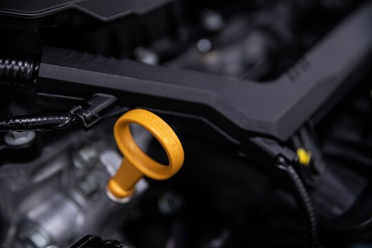 Yellow dipstick for measuring the amount of engine oil in the car. Car lubrication system.