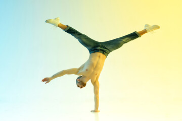 Shirtless male acrobat doing handstand