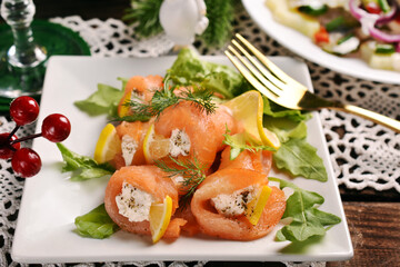 Smoked salmon rolls with cheese on Christmas table