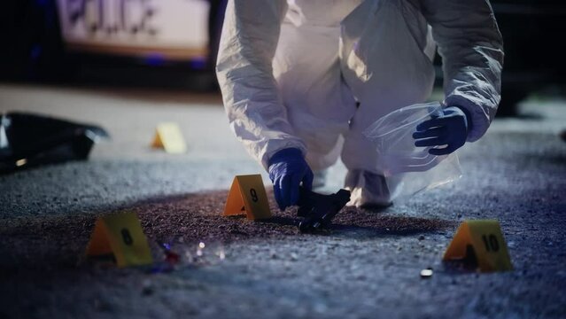 Forensics Finding Murder Weapon on Crime Scene at Night and Packing it in Professional Bag. Specialist Sending Gun to Lab to Look for Trace Evidence. Gang Fire Exchange Led to Mass Shooting