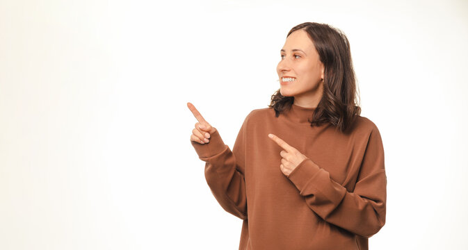 Beautiful Woman Is Double Pointing And Looking Aside Over White Copy Space.