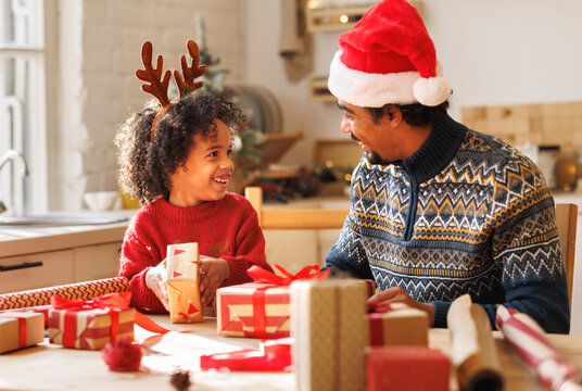 Happy african american family father and kid son pack Christmas gifts
