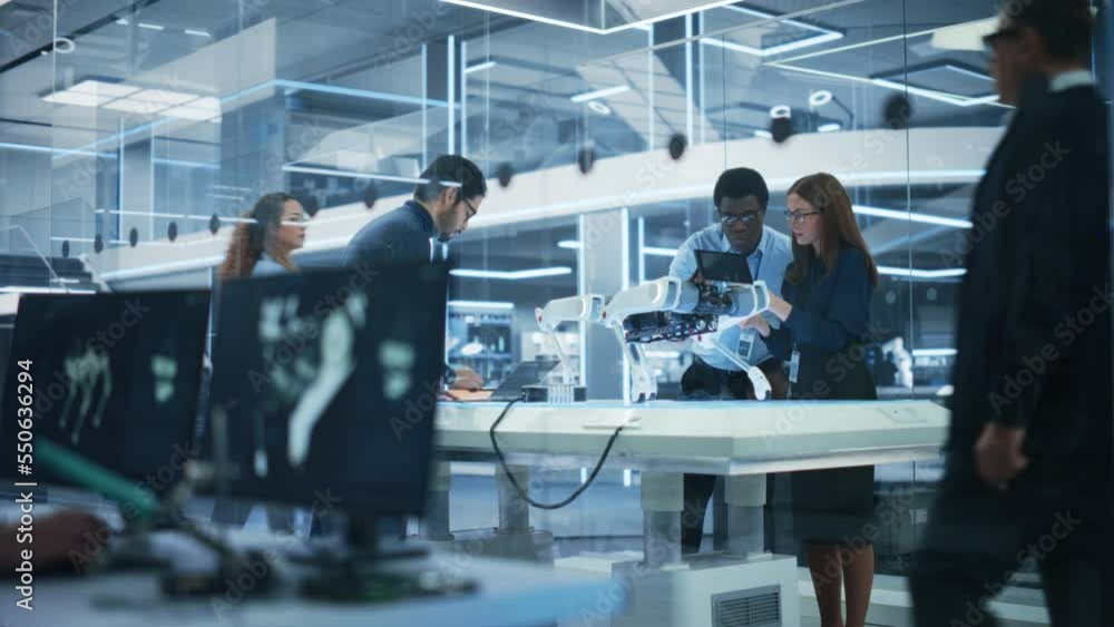 Aufkleber Diverse Team of Industrial Robotics Specialists Gathered Around a Table With a Mobile Robot. Scientists Use Tablet and Laptop Computers to Program the Automated AI Robotic Dog.