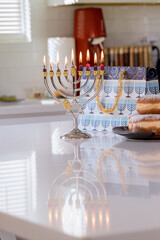 Jewish holiday symbol Hanukkah brightly glowing on Hanukkiah Menorah blurred backdrop
