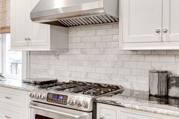 Luxury modern white kitchen details stainless steel stovetop gas appliance coffee maker espresso...