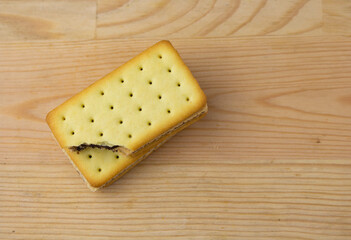 Cracker sandwiches with chocolate and cheese filling on wooden background