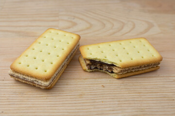 Pile of cracker sandwiches with chocolate and cheese filling on wooden background