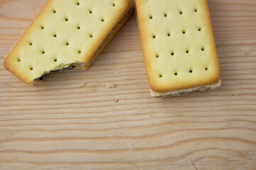Cracker sandwiches with chocolate and cheese filling on wooden background