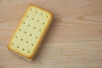 Cracker sandwiches with chocolate and cheese filling on wooden background