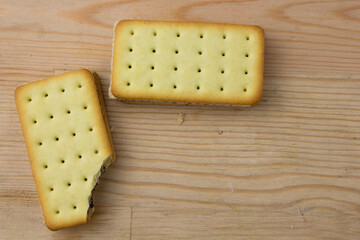 Cracker sandwiches with chocolate and cheese filling on wooden background