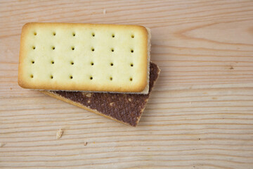 Cracker sandwiches with chocolate and cheese filling on wooden background