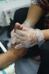 A foot massage is being performed by a male masseur