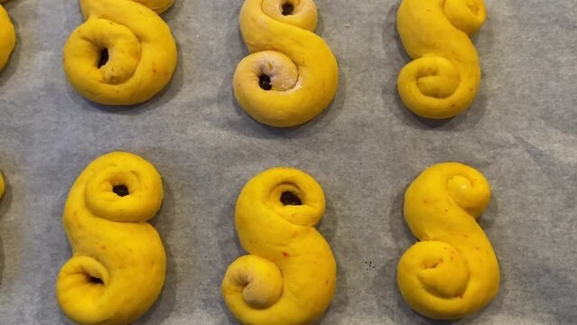 Baking Swedish saffron buns for Christmas holiday. Close up of person adding raisin to the Swedish saffron braid dough. Footage made in Sweden.