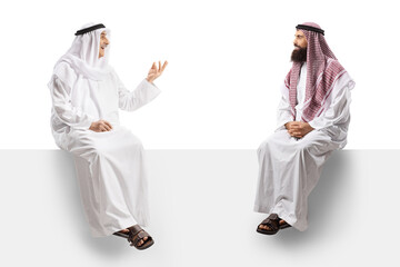 Two arab men seated on a white panel having a conversation