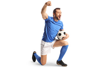 Football player with a ball kneeling and gesturing win