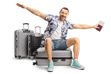 Male tourist sitting on a suitcase and spreading arms to fly