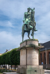 Copenhagen, Denmark - July 24, 2022: Closeup of King Christian X equestrian greenish bronze statue on beige stone pedestal at Saint Anna square under blue cloudscape
