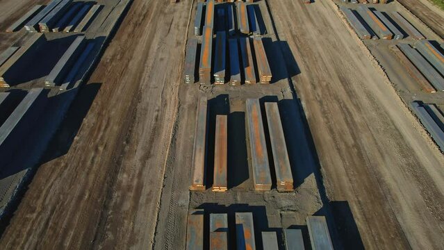 View of made steel billets and slabs in urban area of steel factory manufacturing. Steel used for production of auto EV electric motor, packaging beverage cans and construction.