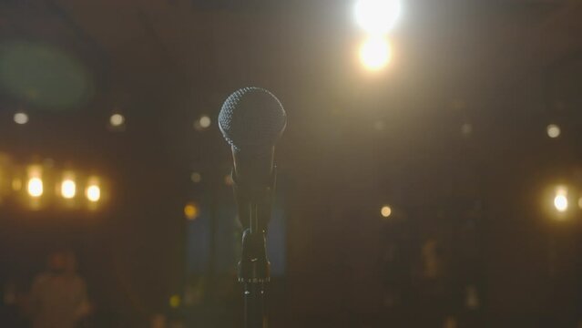 Microphone in bright light. An empty hall without spectators. Concert hall scene. Waiting for the performance of an artist, singer, politician. World crisis, financial losses