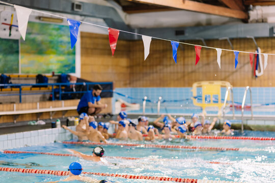 Coach speaking to kids in pool - Powered by Adobe